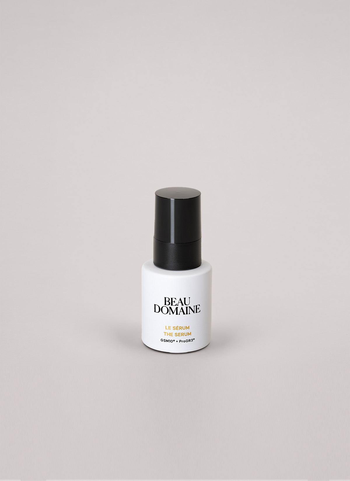 Frasco branco de sérum com tampa preta sobre fundo cinzento claro